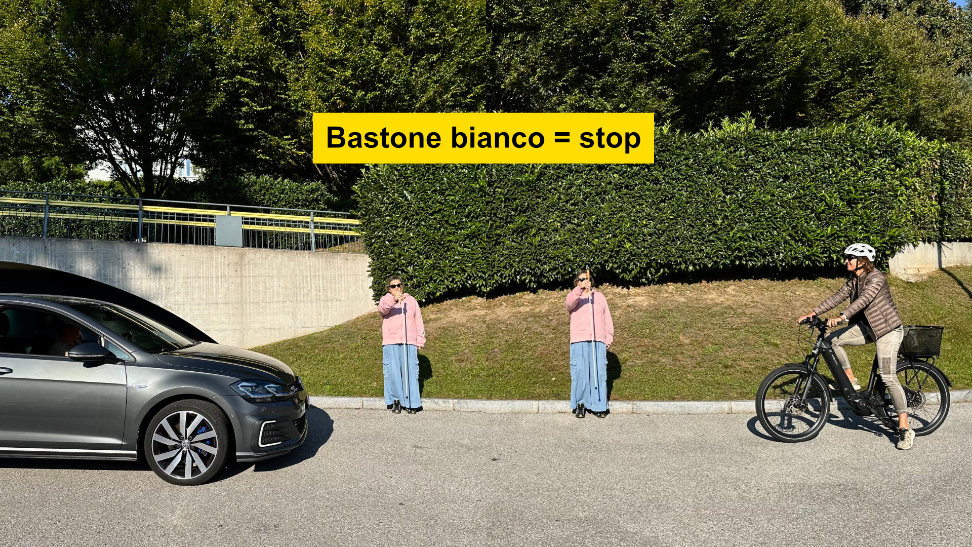 Bastone bianco = stop. Quando Corinne alza il bastone bianco, sia l'auto che la bicicletta si fermano.